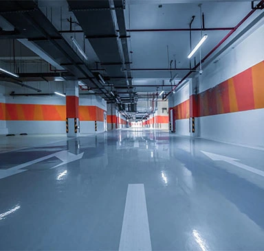 An empty parking garage with orange and white stripes.